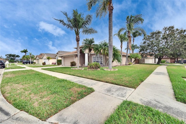 view of front facade featuring a front lawn, concrete driveway, an attached garage, and stucco siding