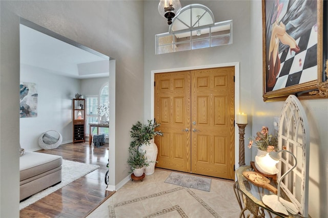 entryway featuring a high ceiling, wood finished floors, and baseboards