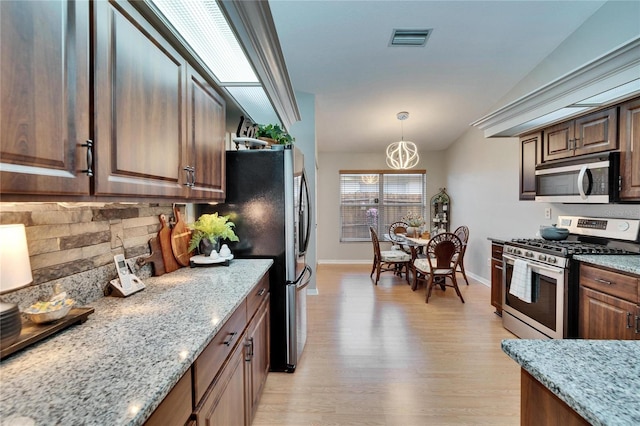 kitchen featuring light stone countertops, visible vents, and stainless steel appliances