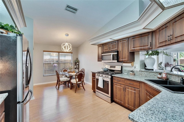 kitchen with a sink, visible vents, a healthy amount of sunlight, light wood-style floors, and appliances with stainless steel finishes