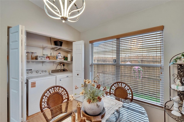 dining space featuring lofted ceiling, a chandelier, and independent washer and dryer