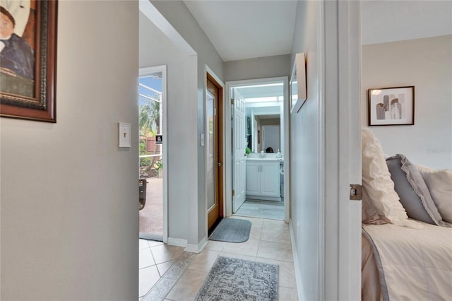 corridor featuring light tile patterned floors and baseboards