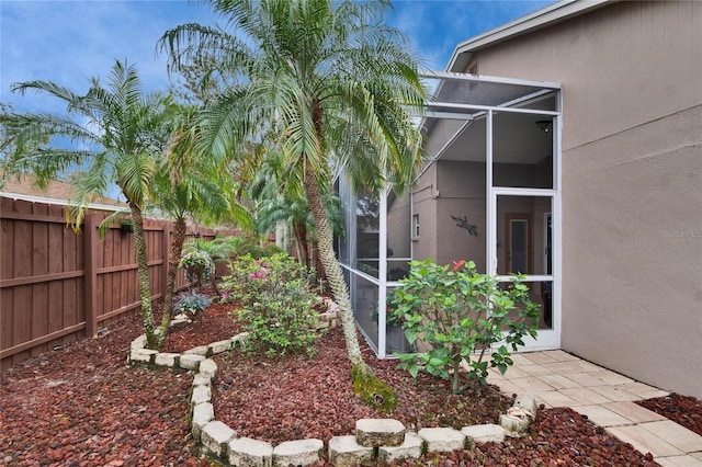 view of yard featuring a lanai and fence