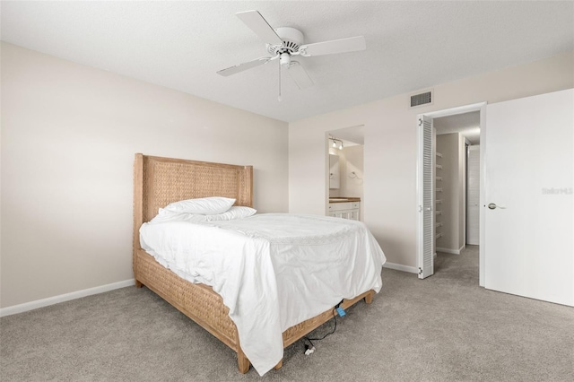 bedroom with visible vents, carpet flooring, ceiling fan, ensuite bath, and baseboards