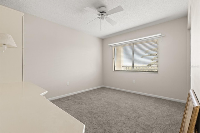 carpeted empty room featuring a textured ceiling, baseboards, and a ceiling fan