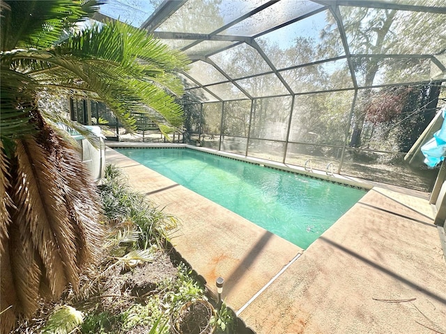 pool featuring glass enclosure and a patio