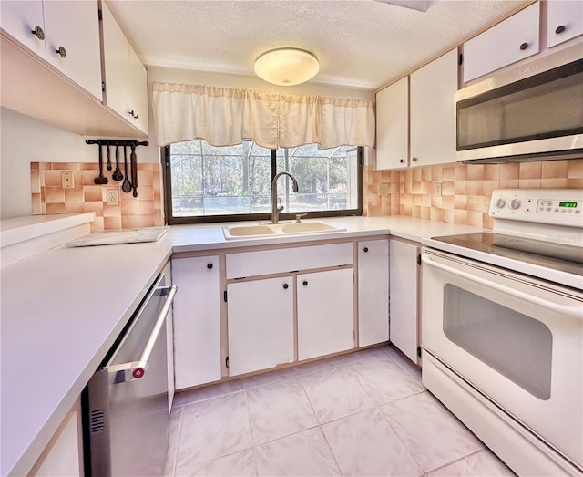 kitchen featuring stainless steel appliances, plenty of natural light, a sink, and light countertops