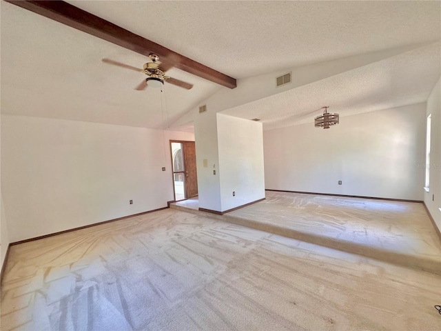 unfurnished room with a textured ceiling, lofted ceiling with beams, light carpet, and visible vents