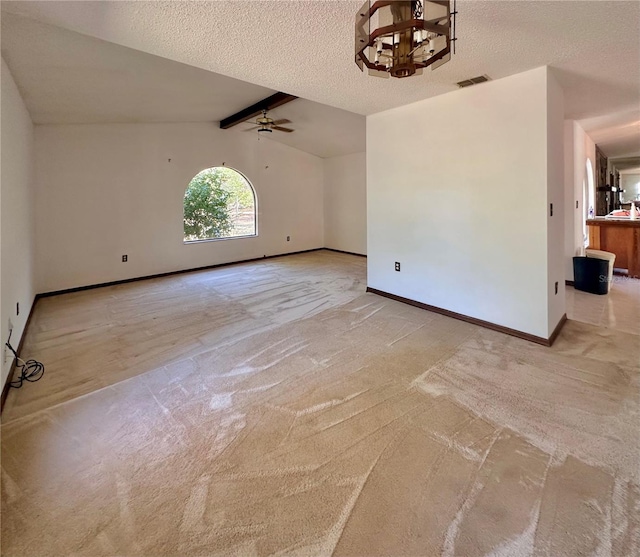 spare room with baseboards, visible vents, lofted ceiling with beams, and a textured ceiling