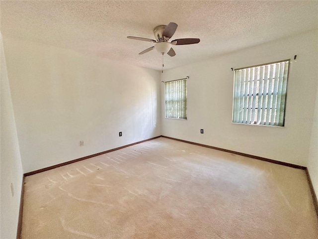 unfurnished room featuring a textured ceiling, carpet flooring, and baseboards