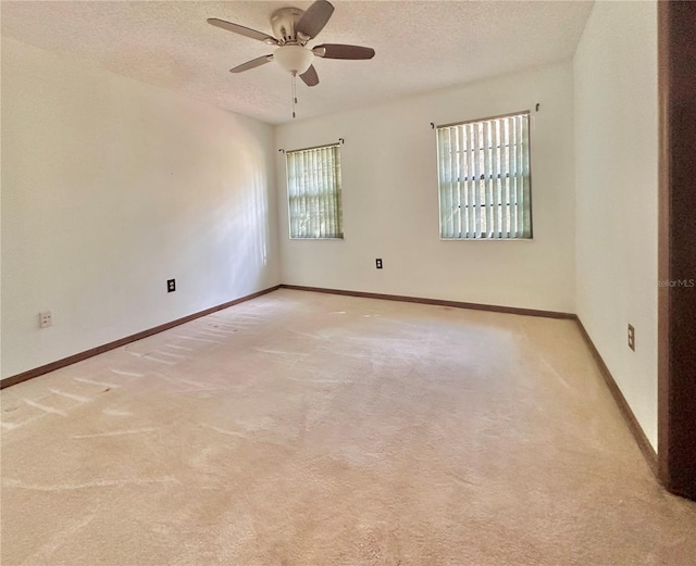 unfurnished room with baseboards, a textured ceiling, and light colored carpet