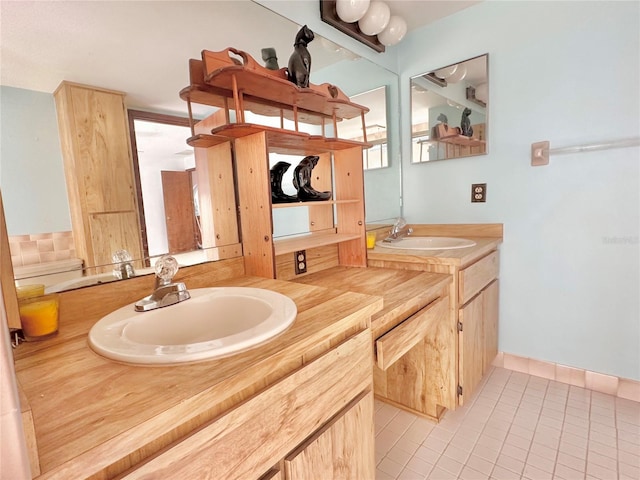 bathroom with tile patterned flooring, a sink, and double vanity