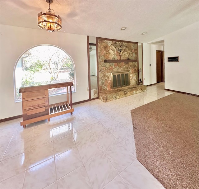 living area featuring a textured ceiling, a fireplace, tile patterned flooring, and baseboards