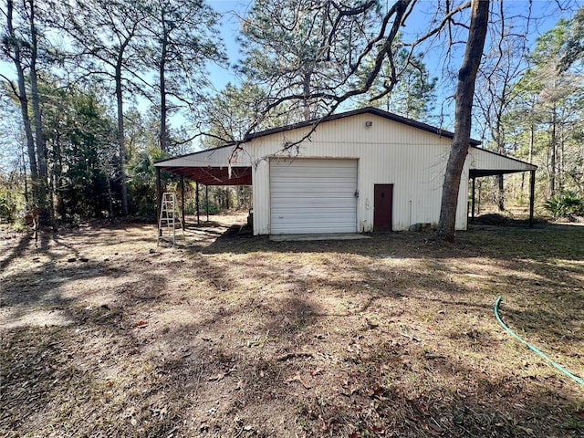 garage with dirt driveway and a detached garage