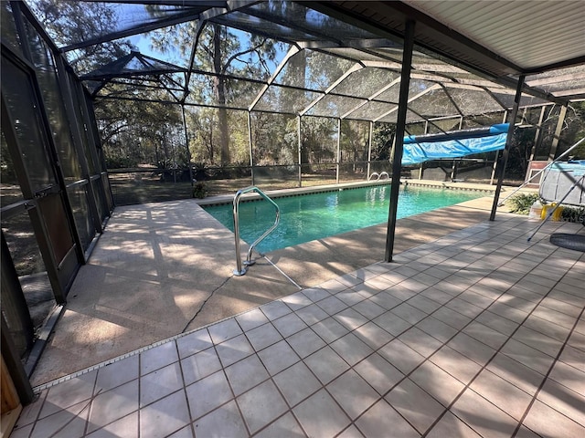 outdoor pool featuring glass enclosure and a patio