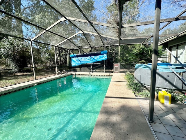 pool with glass enclosure, a patio area, and a jacuzzi