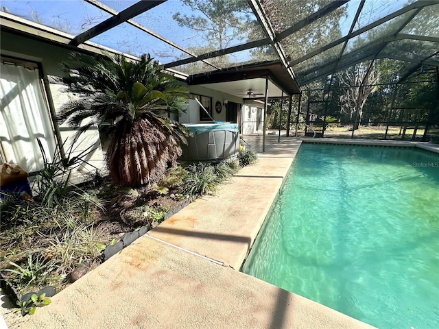 pool featuring glass enclosure, a ceiling fan, and a patio