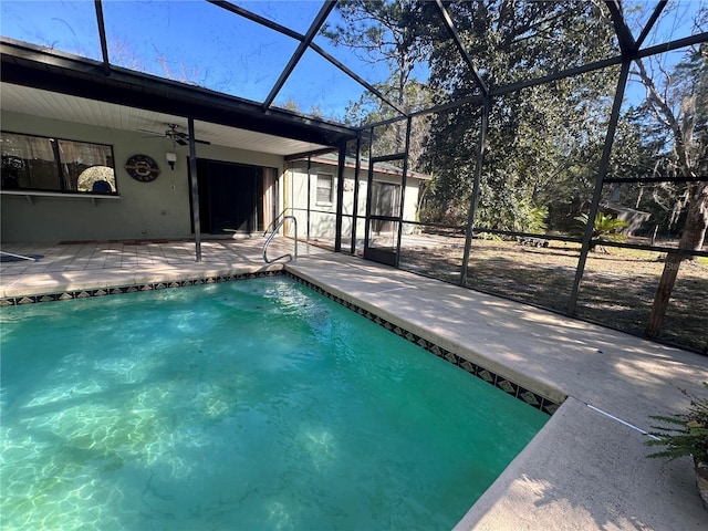 pool with a patio area, glass enclosure, and a ceiling fan