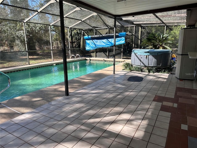 outdoor pool featuring glass enclosure and a patio