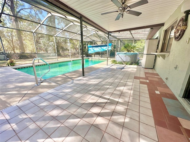 outdoor pool with ceiling fan, a patio, and glass enclosure