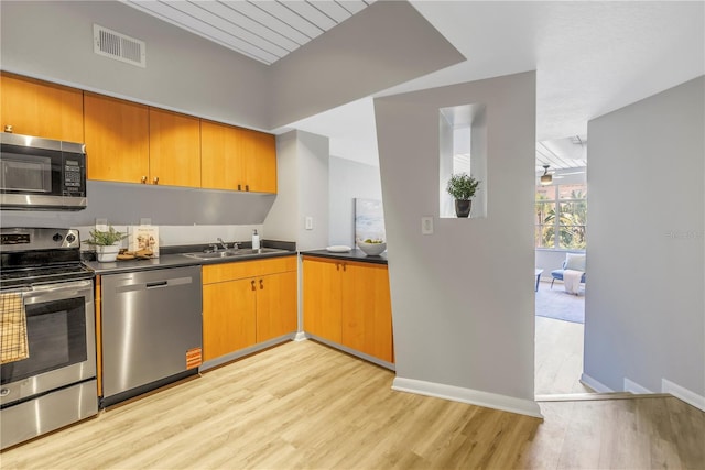 2402 W Azeele St Unit 423, Tampa, FL 33609 - kitchen featuring appliances with stainless steel finishes, light wood-style floors, and dark countertops