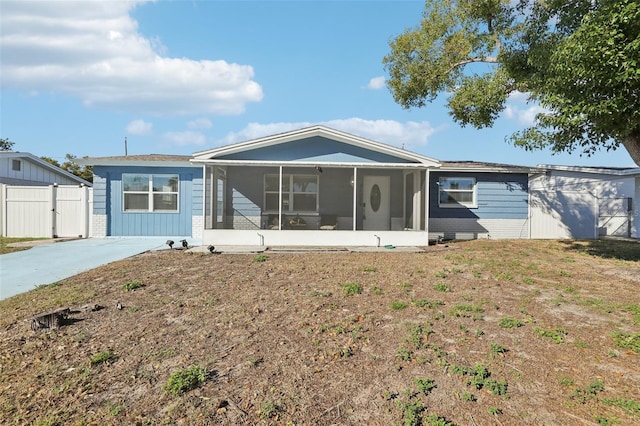 view of front of property with a sunroom and fence