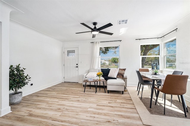 living area featuring visible vents, ceiling fan, light wood-style flooring, and baseboards