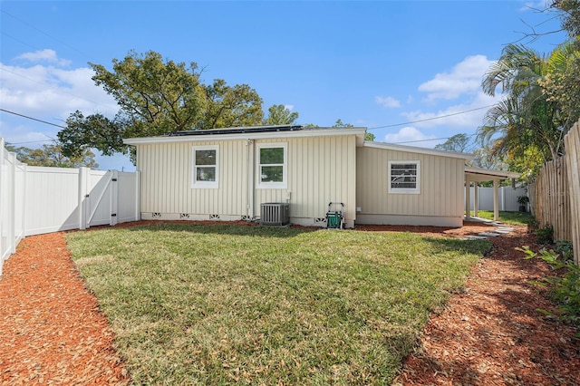 rear view of house with crawl space, a fenced backyard, a gate, and a lawn