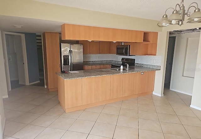 kitchen featuring tasteful backsplash, appliances with stainless steel finishes, light tile patterned flooring, dark stone counters, and a peninsula