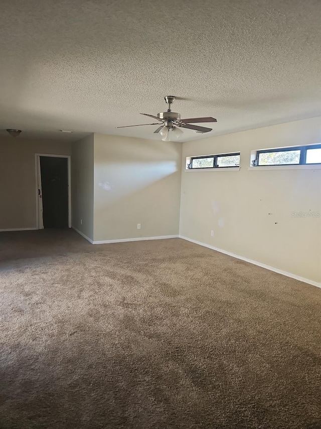 unfurnished room with a ceiling fan, carpet, baseboards, and a textured ceiling