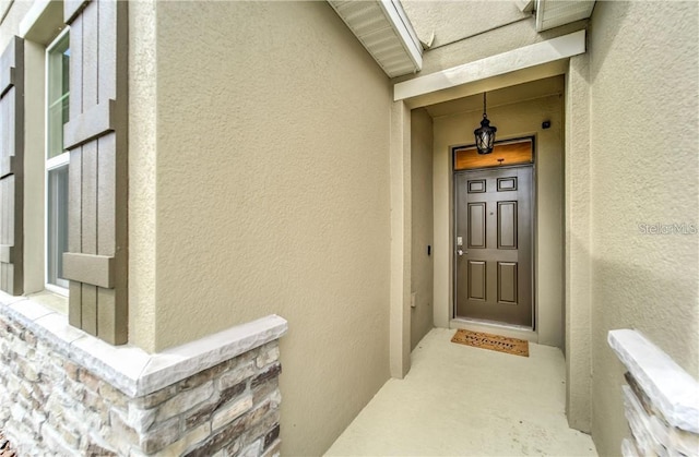 view of exterior entry with stucco siding