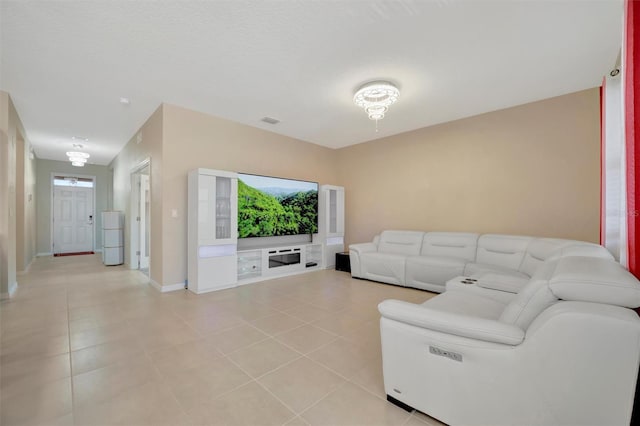 living area with light tile patterned flooring, visible vents, and baseboards