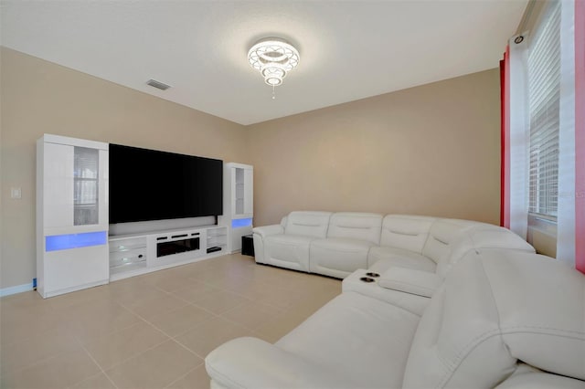 living room with light tile patterned floors, visible vents, and baseboards