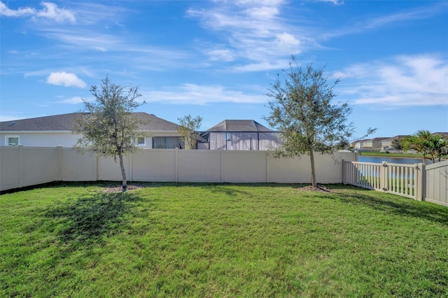 view of yard featuring a fenced backyard and a water view