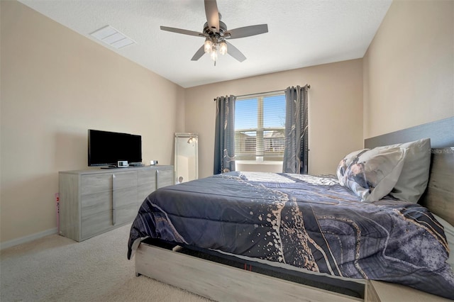 carpeted bedroom featuring visible vents, a textured ceiling, a ceiling fan, and baseboards