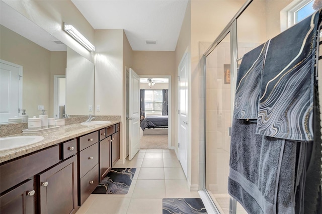 ensuite bathroom featuring tile patterned flooring, visible vents, ensuite bath, and a sink