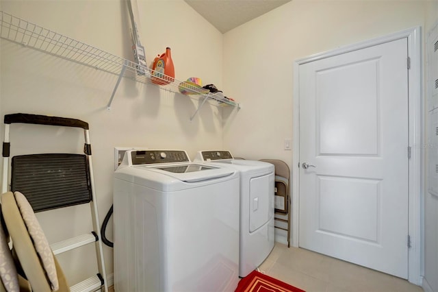 laundry room featuring light tile patterned floors, laundry area, and independent washer and dryer