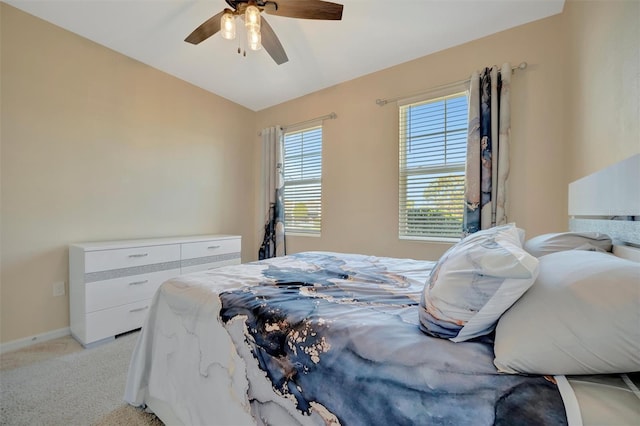 bedroom featuring light carpet, a ceiling fan, baseboards, and vaulted ceiling