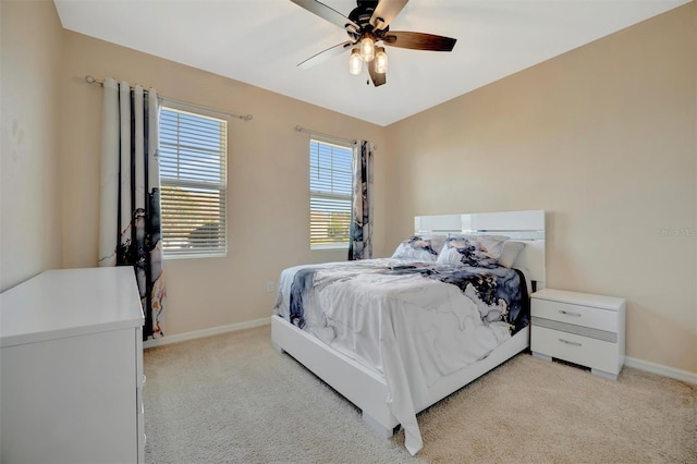 bedroom featuring light carpet, ceiling fan, and baseboards