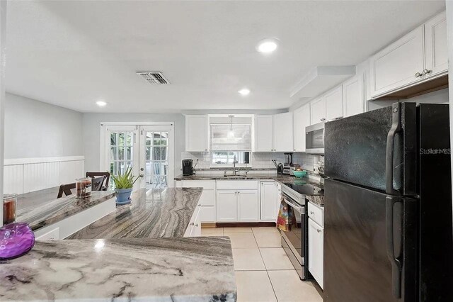 kitchen with light tile patterned floors, visible vents, french doors, appliances with stainless steel finishes, and decorative backsplash