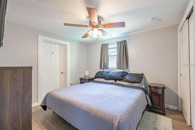 bedroom featuring ceiling fan, light wood finished floors, a closet, and baseboards