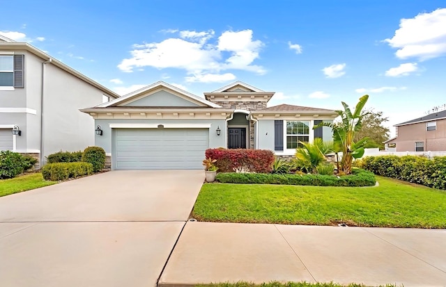 view of front of house with stucco siding, a front lawn, driveway, stone siding, and a garage