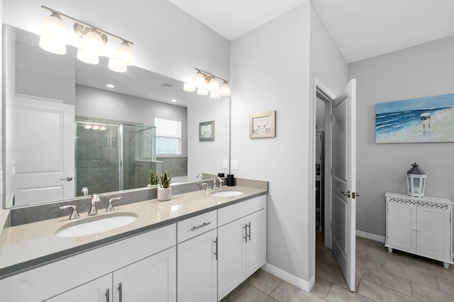 bathroom featuring a sink, double vanity, a shower stall, and tile patterned flooring