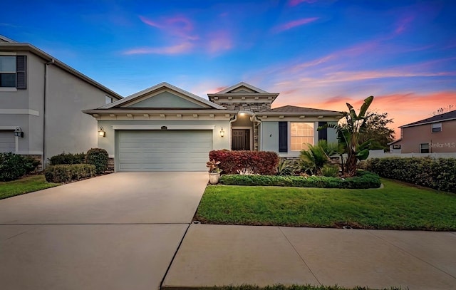 ranch-style house with concrete driveway, a front yard, stucco siding, a garage, and stone siding