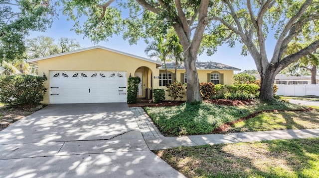6041 16th Ln NE, Saint Petersburg, FL 33703 - ranch-style house with fence, stucco siding, an attached garage, and driveway