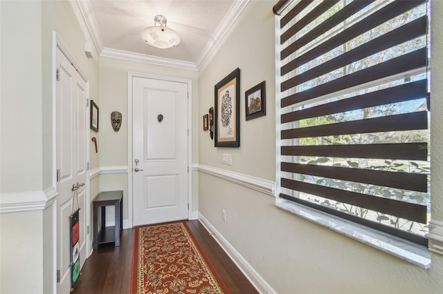 doorway with ornamental molding, dark wood finished floors, and baseboards