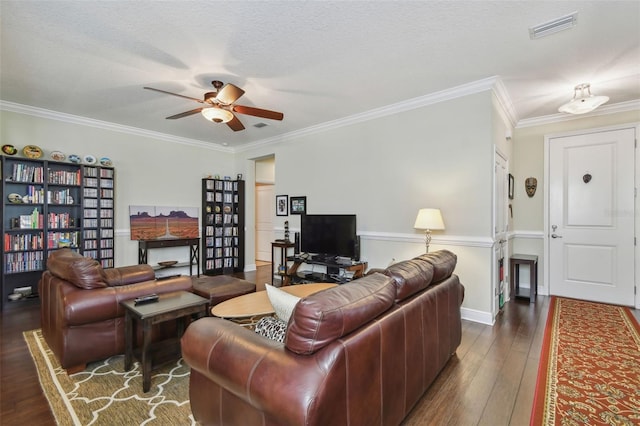 living room with ceiling fan, a textured ceiling, hardwood / wood-style flooring, visible vents, and crown molding