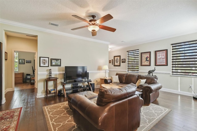 living room featuring ornamental molding, visible vents, a textured ceiling, and hardwood / wood-style floors