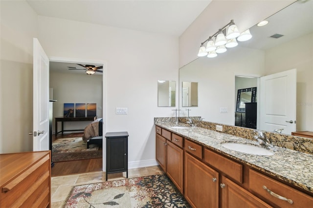 bathroom featuring double vanity, a sink, visible vents, and connected bathroom