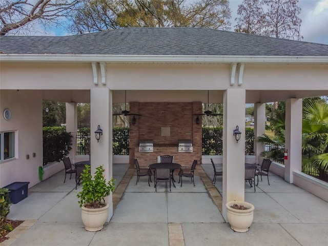 view of patio featuring exterior kitchen, outdoor dining area, ceiling fan, and area for grilling